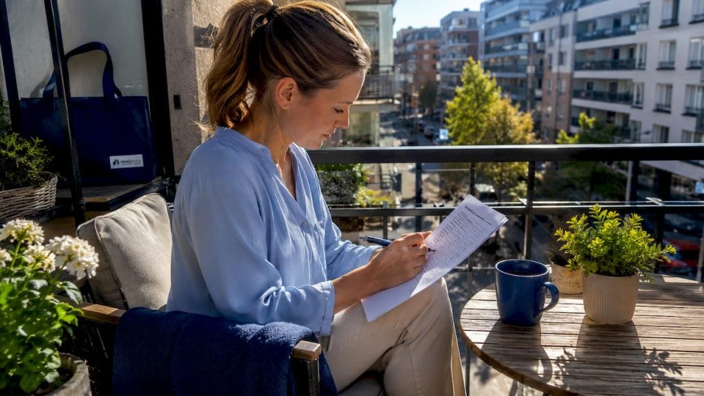 En kvinna sitter vid sitt skrivbord och bläddrar i en ordlista för städbranschen.