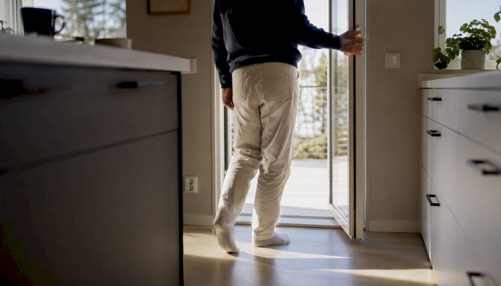 En person öppnar balkongdörren för att släppa in frisk luft.