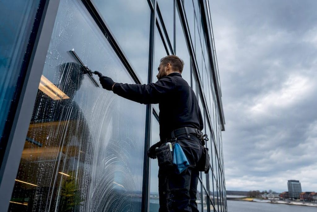 Fönsterputsare som rengör glasfasaden på ett kontor